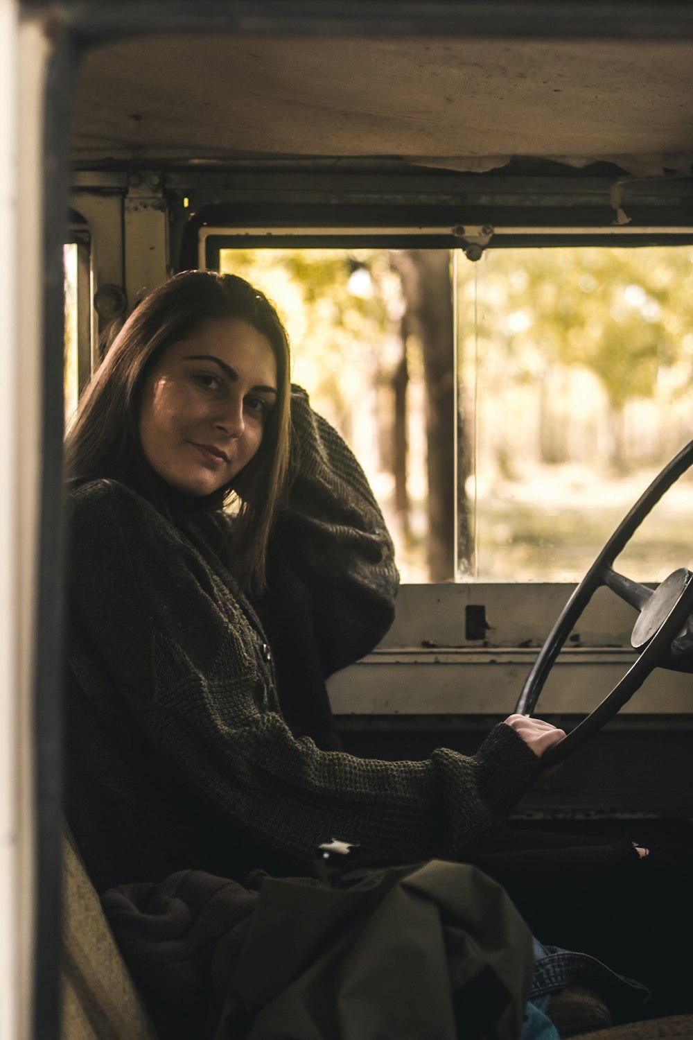 Mujer sentada dentro del vehículo sosteniendo el volante durante el día