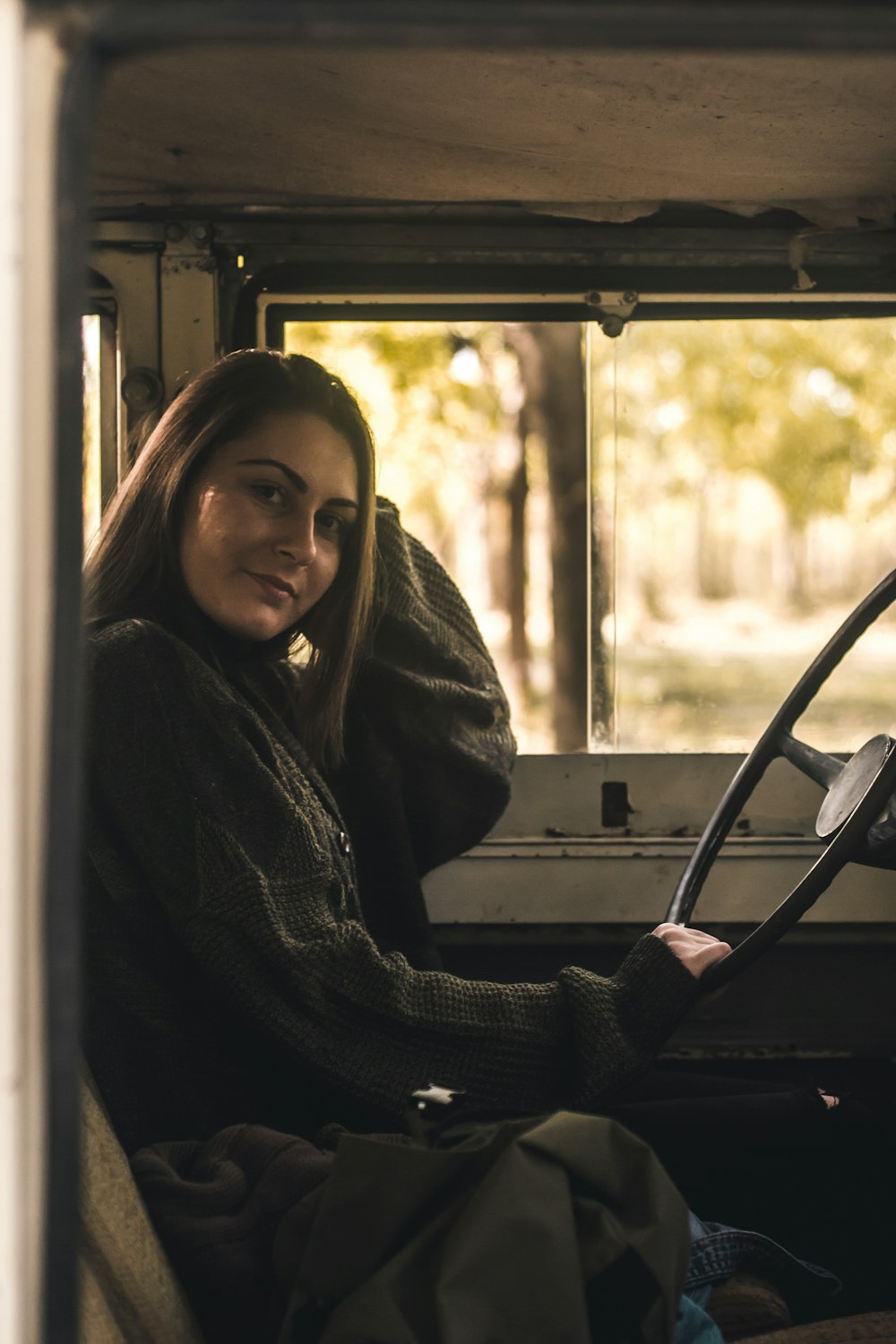 mulher sentada dentro do veículo segurando o volante durante o dia