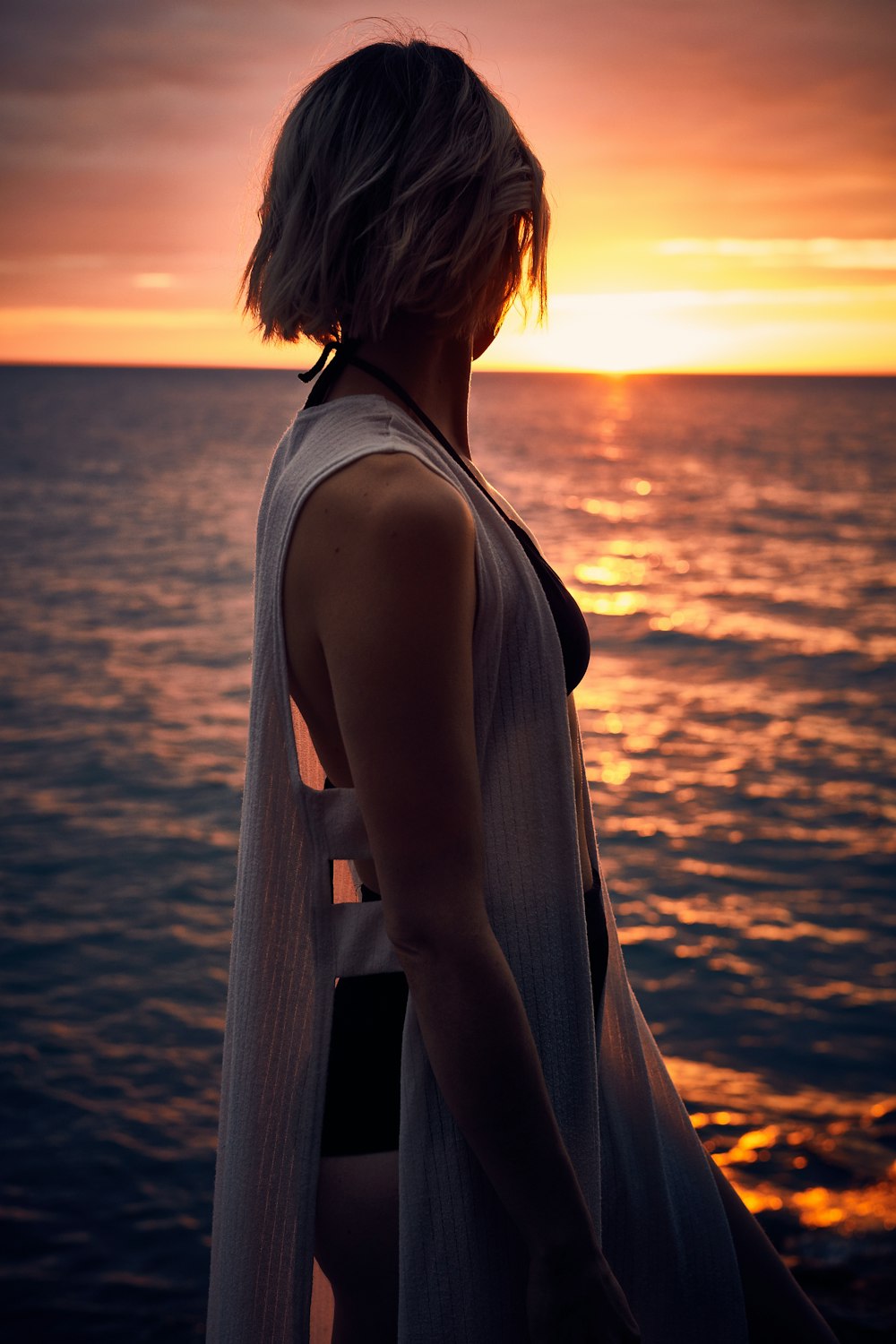 femme faisant face de côté au coucher du soleil