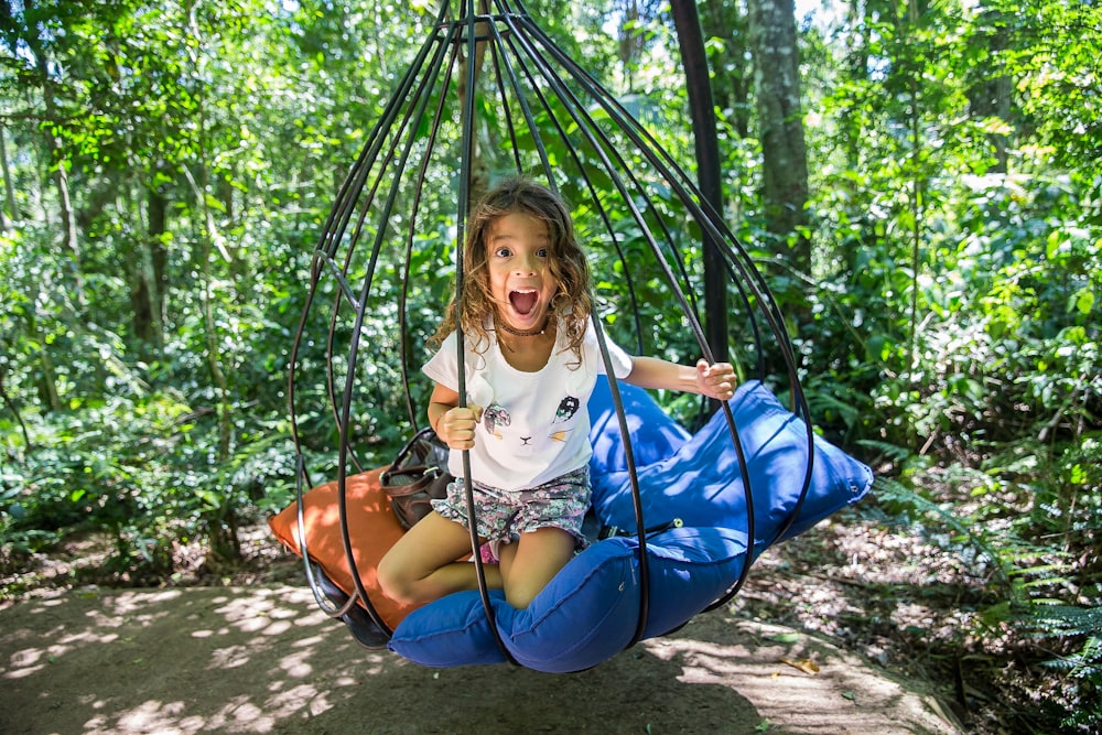 girl sitting on hammock between plants