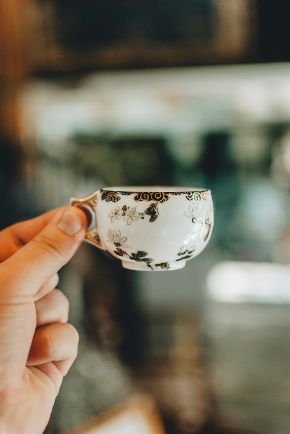 Persona che tiene una tazza da tè in ceramica bianca