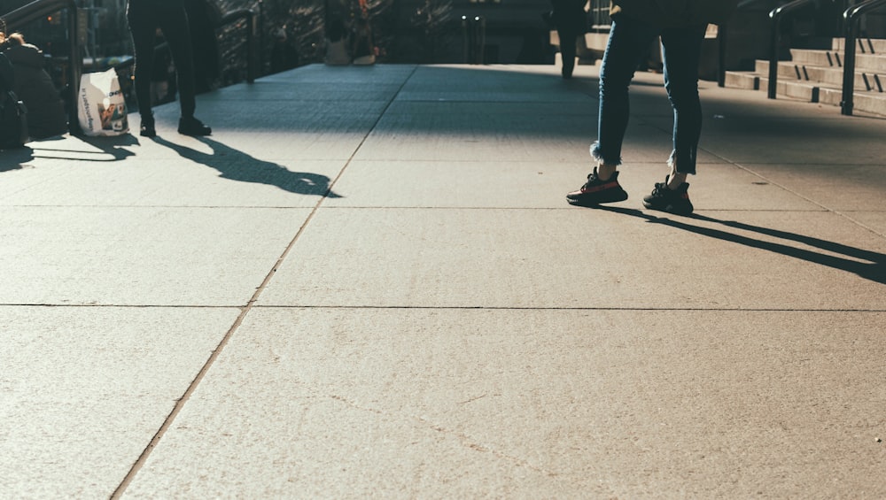 person in blue jeans standing on concrete ground