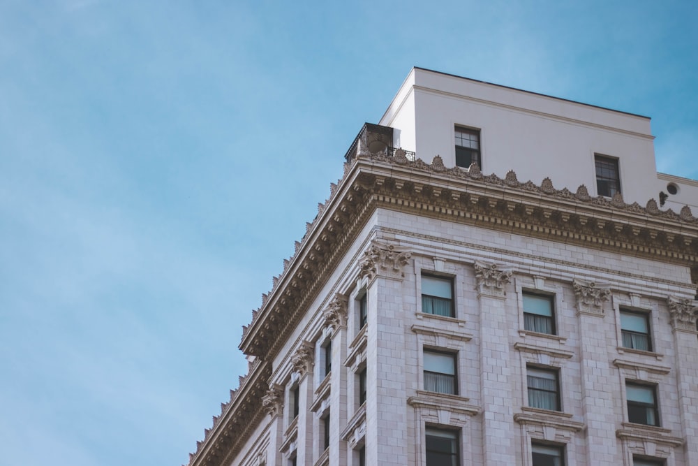 white concrete high-rise building under blue skies