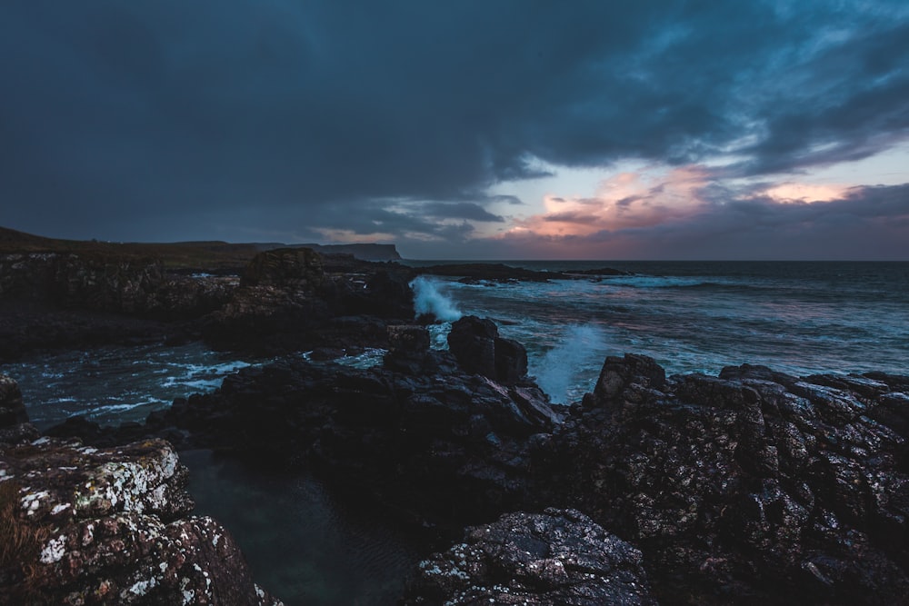 Mar perto de rochas durante nuvens negras