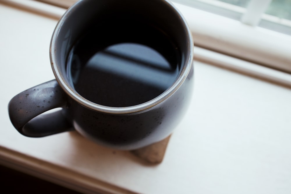 black ceramic mug on white panel