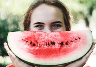 woman holding sliced watermelon