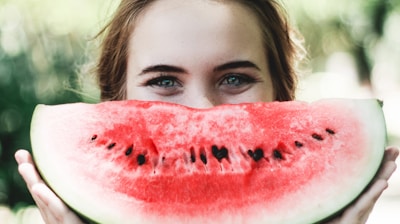 woman holding sliced watermelon