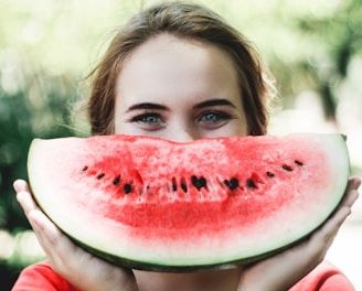 woman holding sliced watermelon