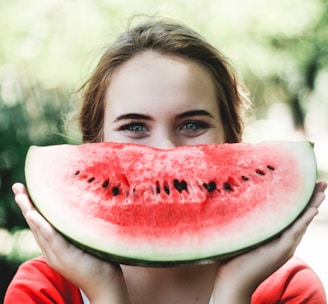 woman holding sliced watermelon