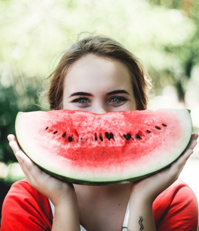 woman holding sliced watermelon