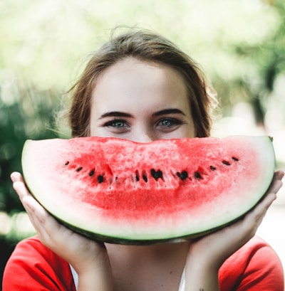 woman holding sliced watermelon