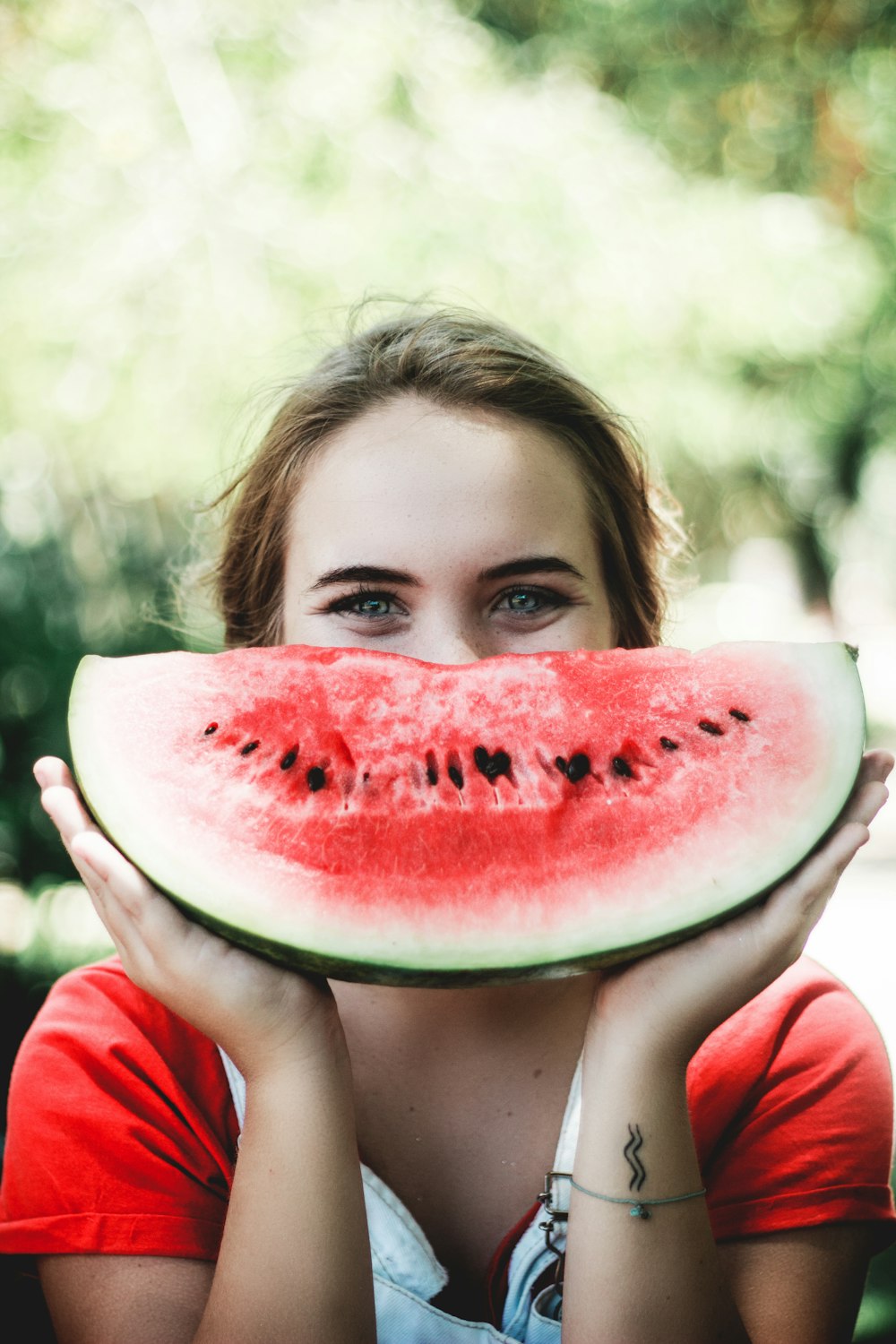 woman holding sliced watermelon