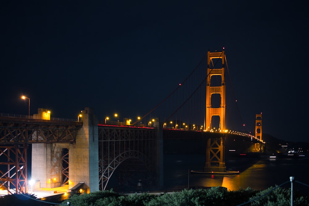 the golden gate bridge is lit up at night