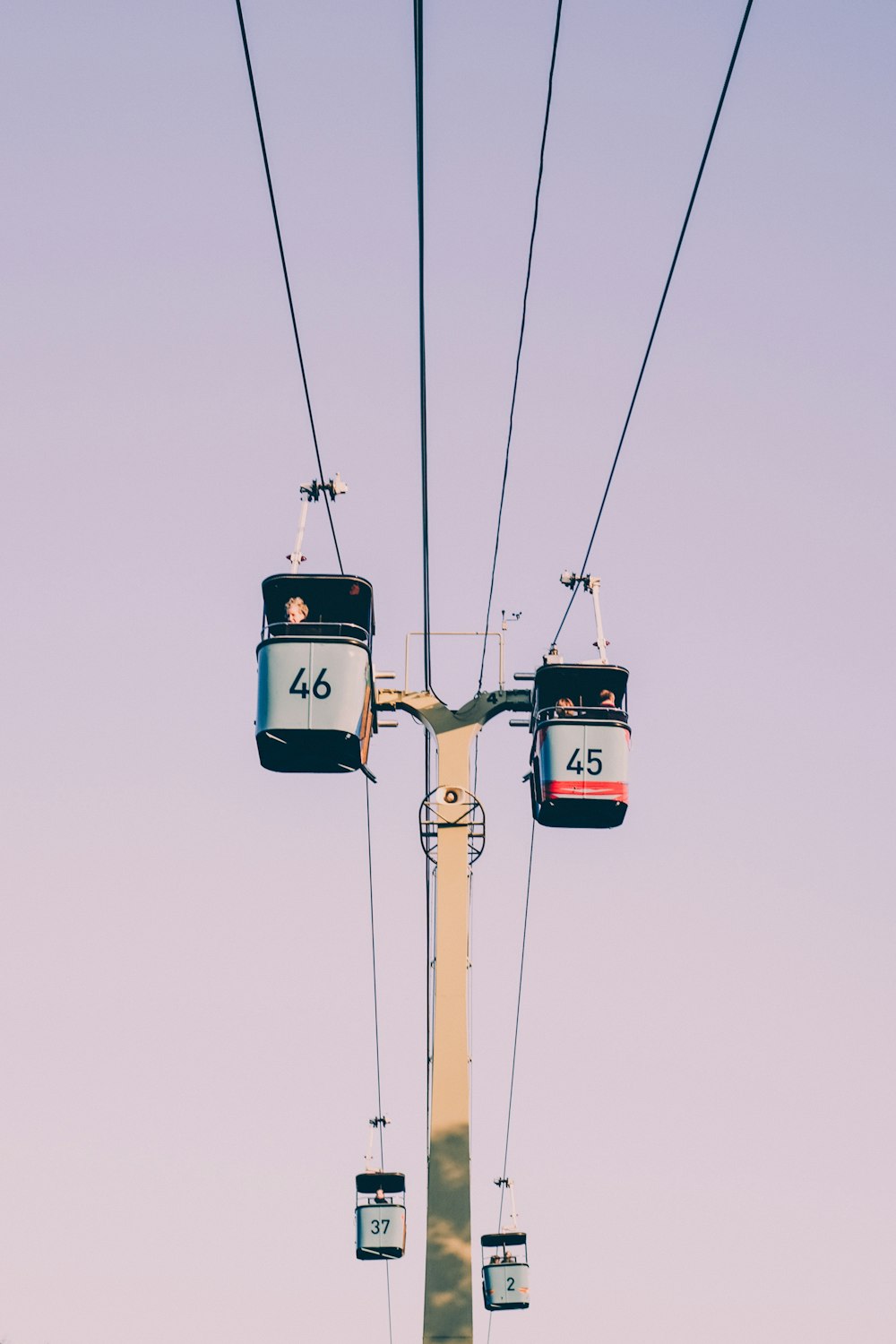 four black-and-gray cable cars crossing