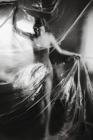 a black and white photo of a woman wrapped in plastic
