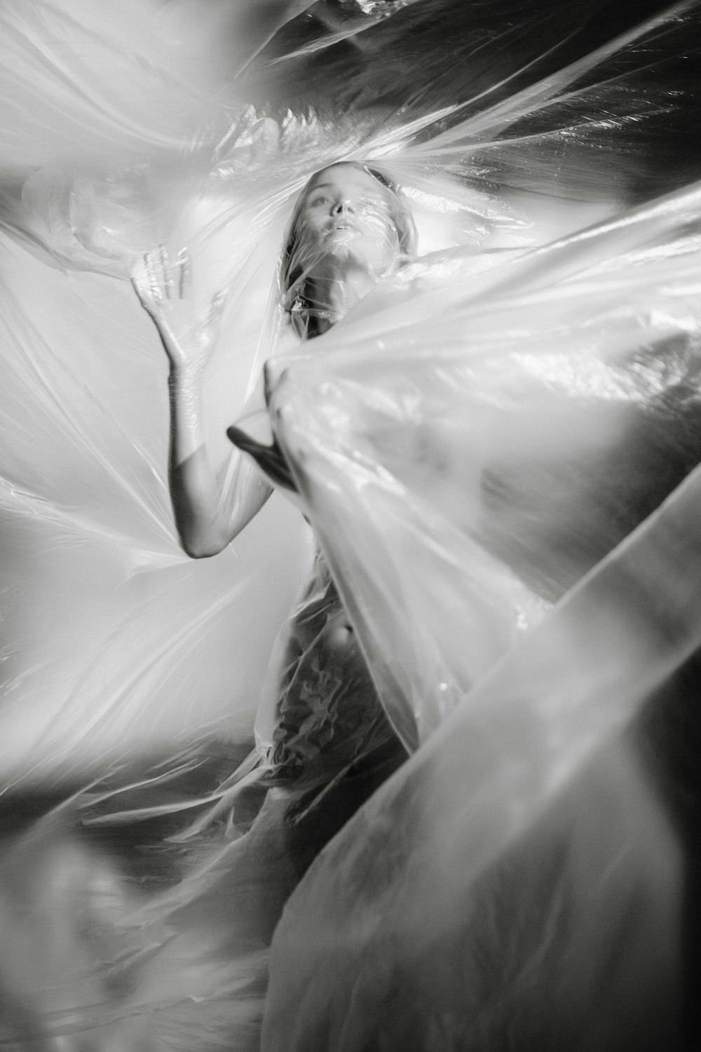 Fotografía en escala de grises de una mujer cubierta de plástico