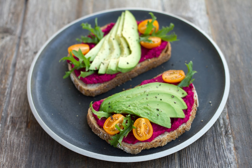 two sliced breads with avocado on top