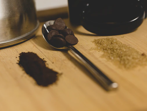 Close-up of a rustic wooden spoon scooping rich, dark cacao paste from a handcrafted ceramic bowl.