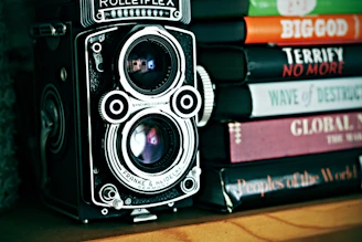 vintage camera beside stack of books