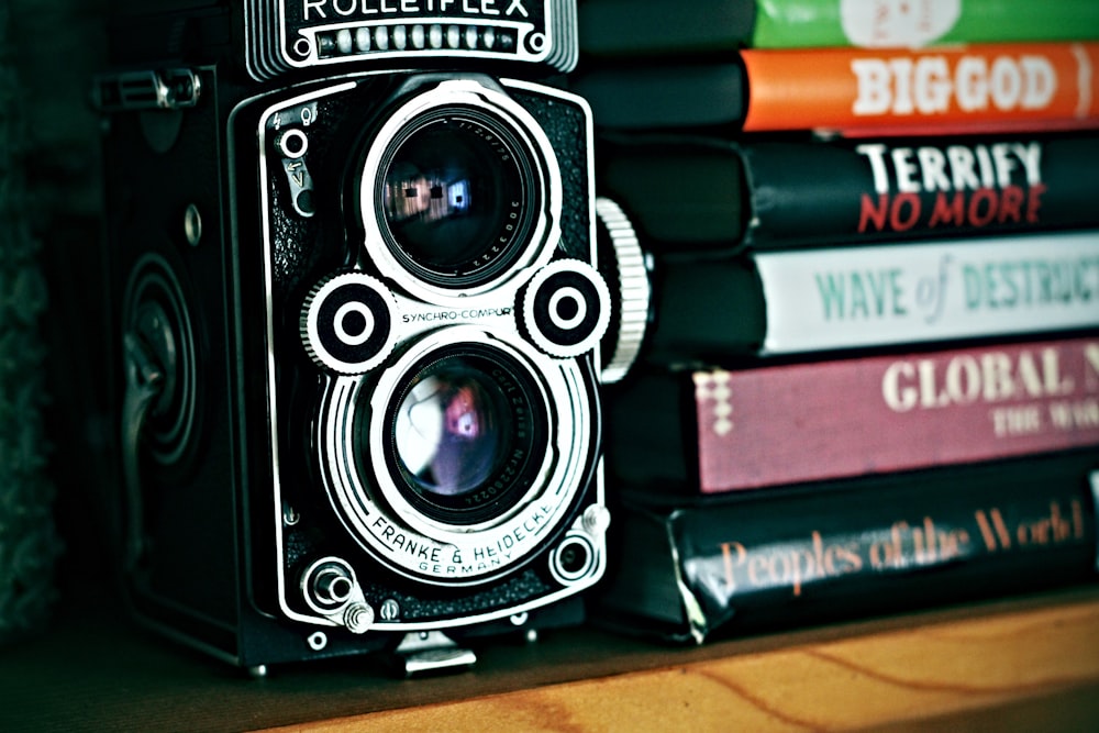 vintage camera beside stack of books