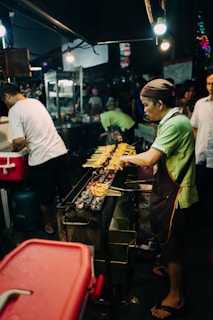 man grilling food barbeque outdoor during night time