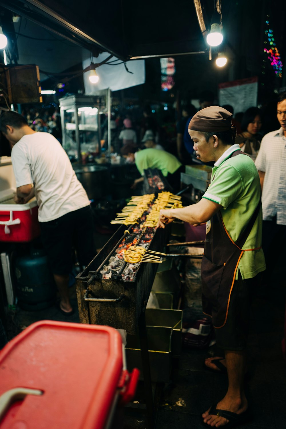 man grilling food barbeque outdoor during night time