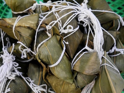 Close-up of recycled paper labels and natural fiber twine tied around sustainable food packaging.