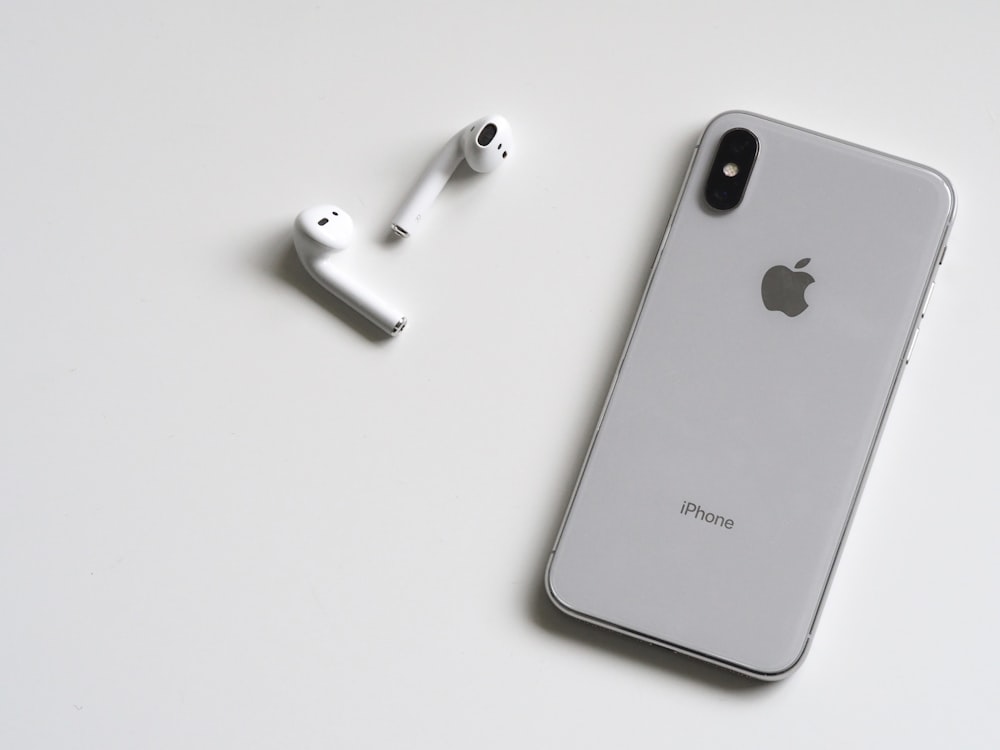 iPhone X plateado y Apple EarPods