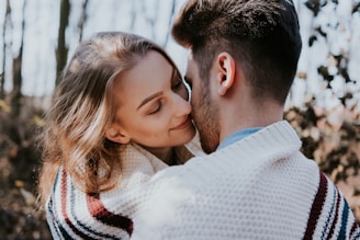man and woman kissing during daytime