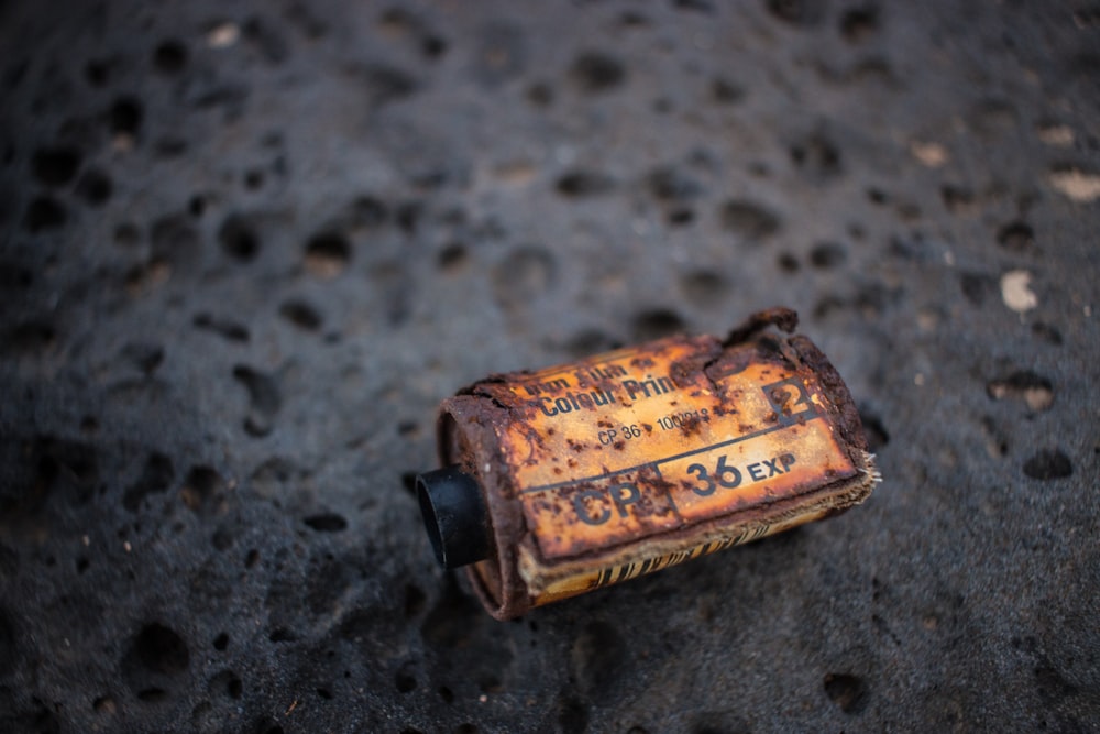 rusted white labeled bottle on gray surface