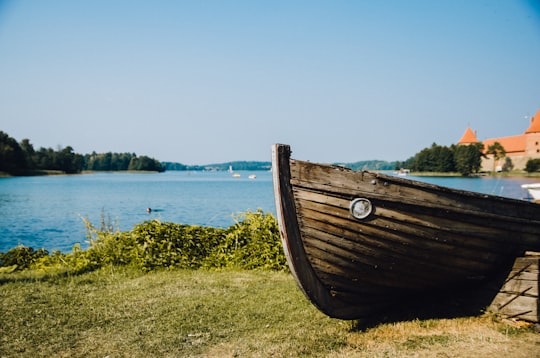 photo of brown boat near body of water in Trakai Lithuania
