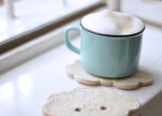 teal ceramic mug with creams near window