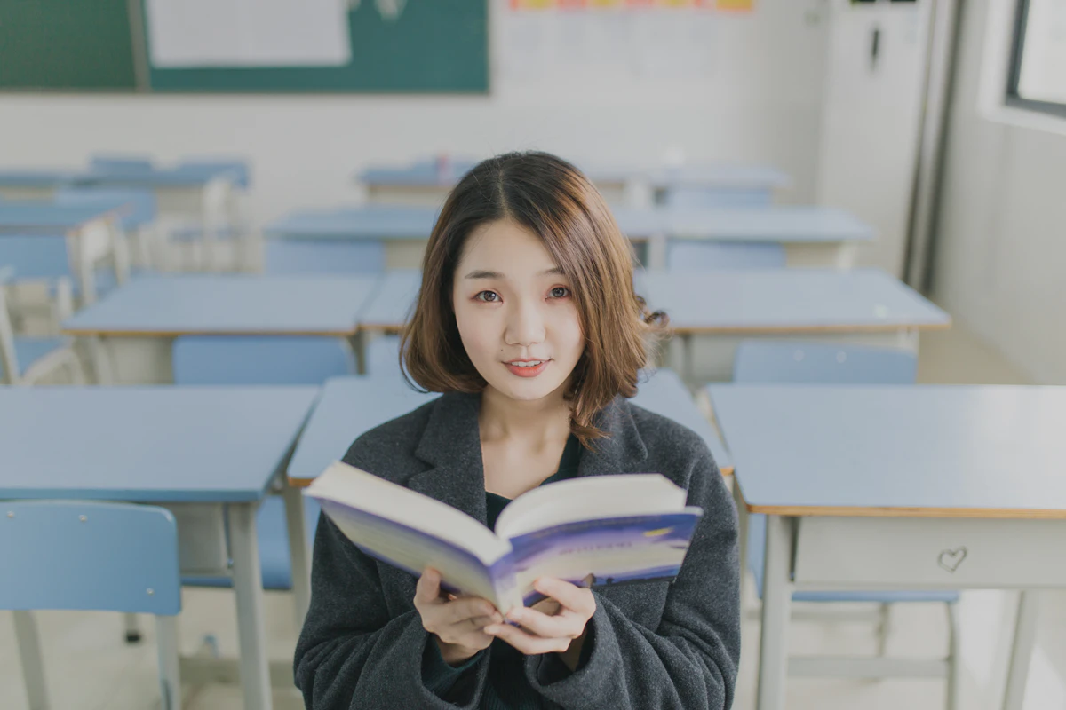 Young woman reading a book in a calm classroom setting