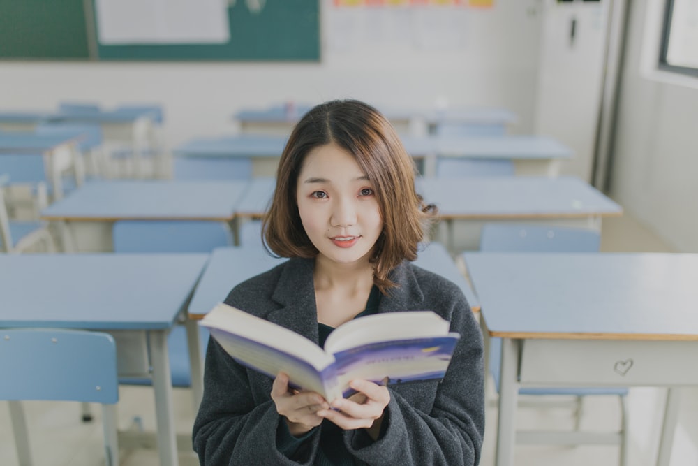 部屋の椅子に座って本を読む女性