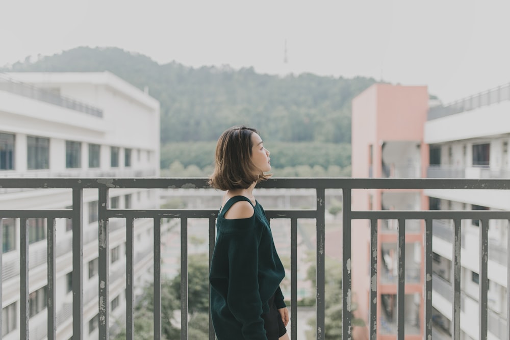 woman facing left beside rails