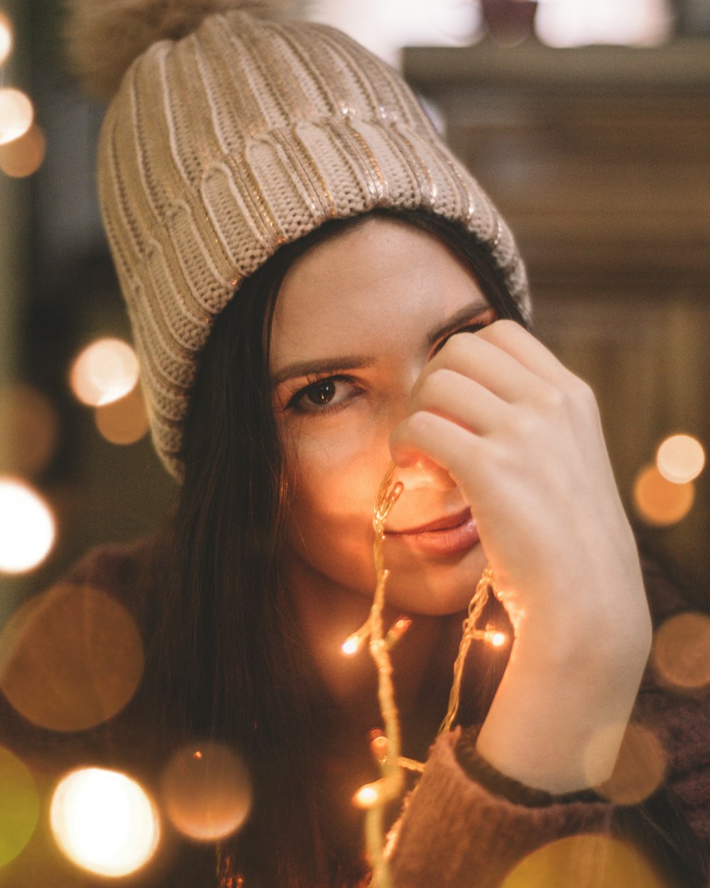 mujer sosteniendo luces de cadena naranja