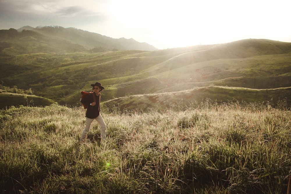 person walking across grassy field