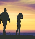 silhouette of man and woman under yellow sky