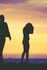 silhouette of man and woman under yellow sky