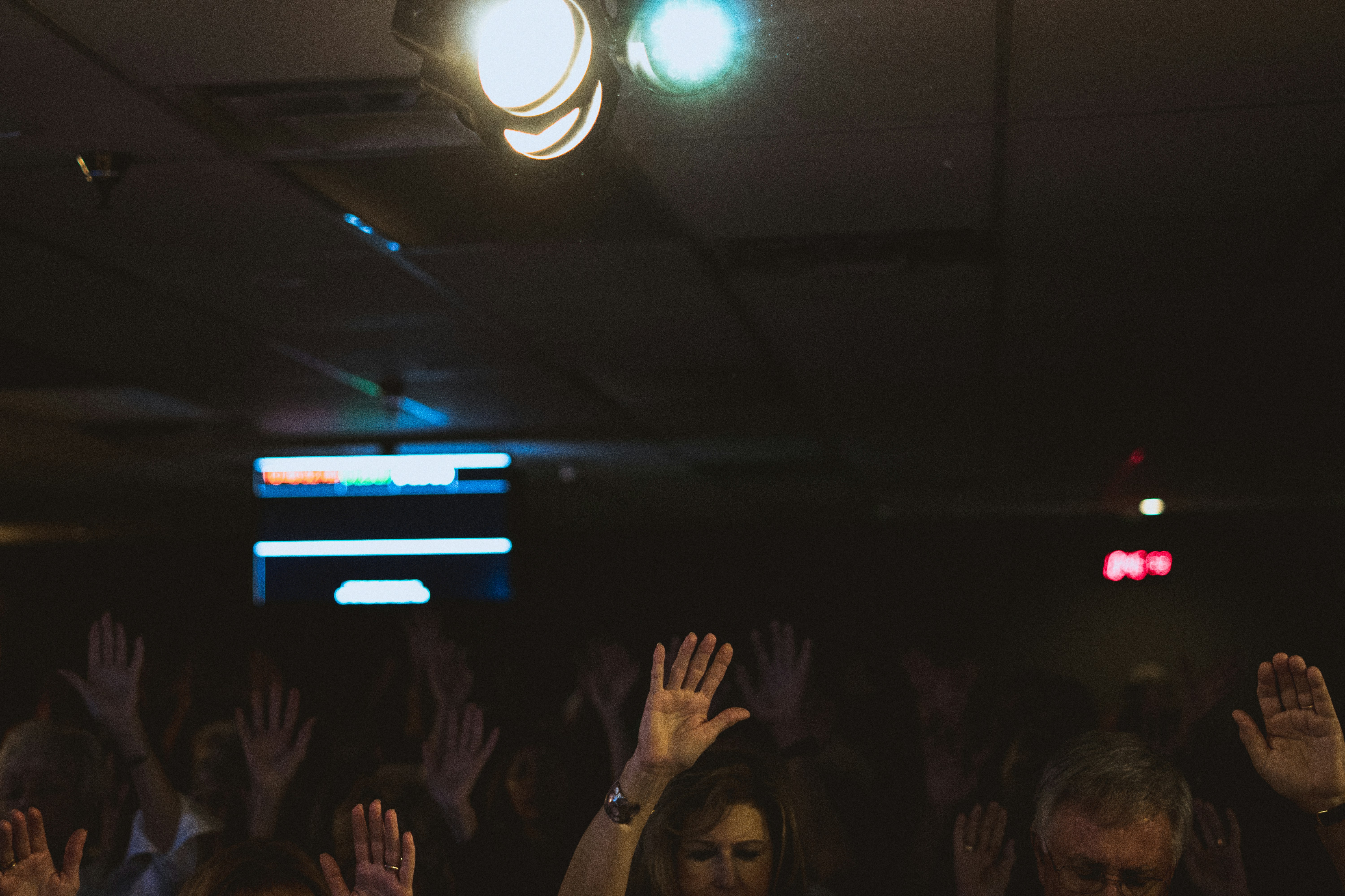 Congregation in joyful worship, hands raised, diverse multicultural church gathering with golden light