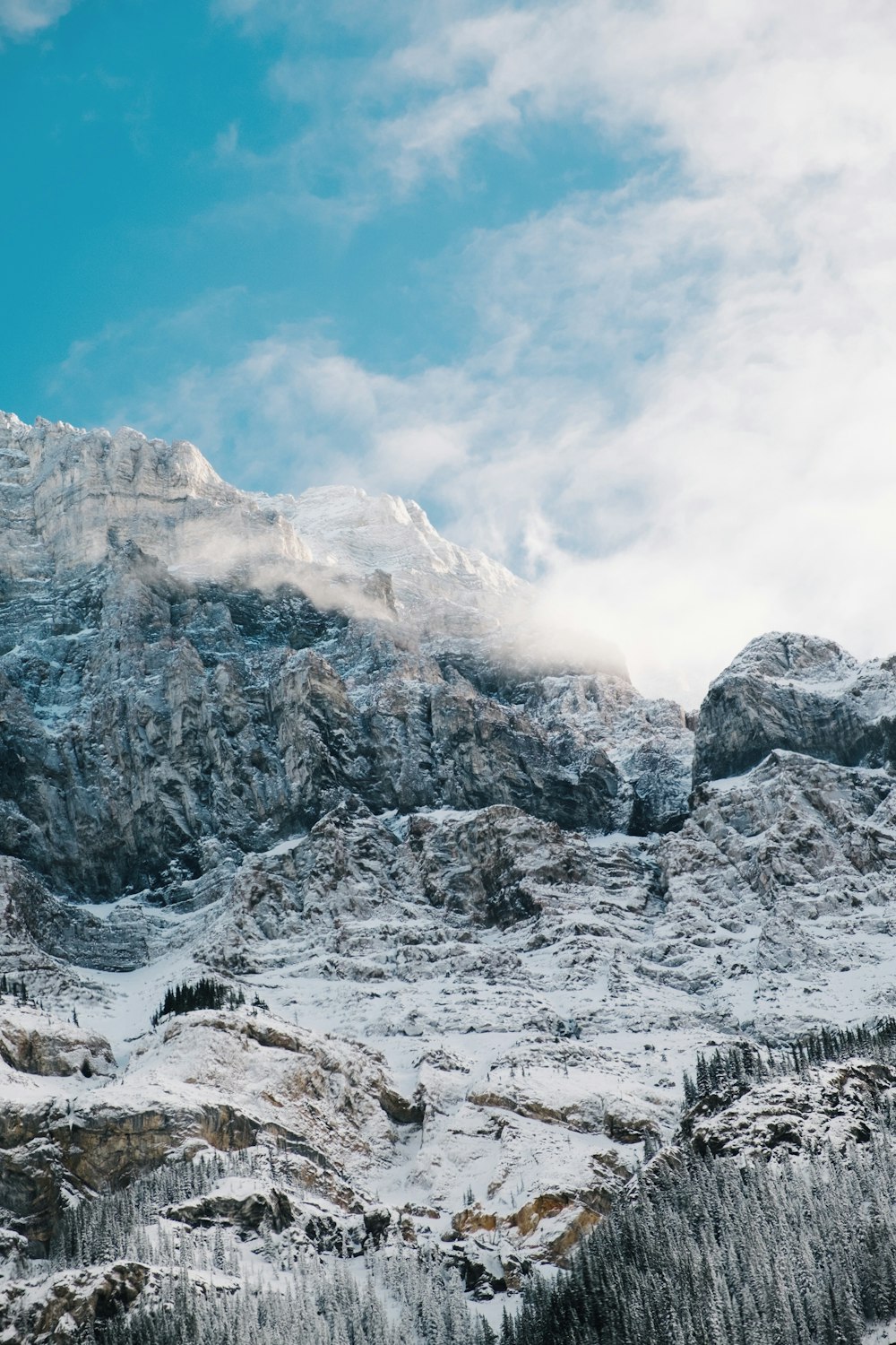 snow covered rock under cloudy sky