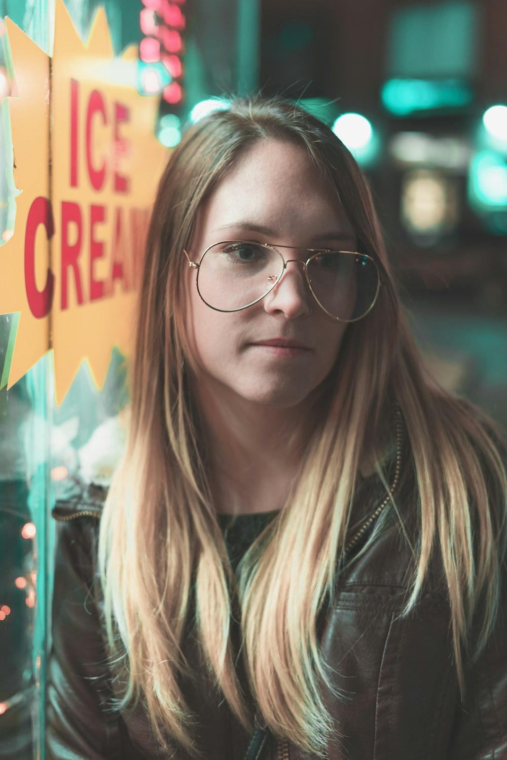 woman in brown leather jacket wearing eyeglasses