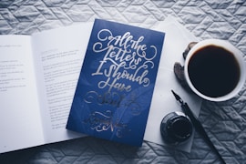 closed All the Letters I Should Have Sent novel book beside filled white cup