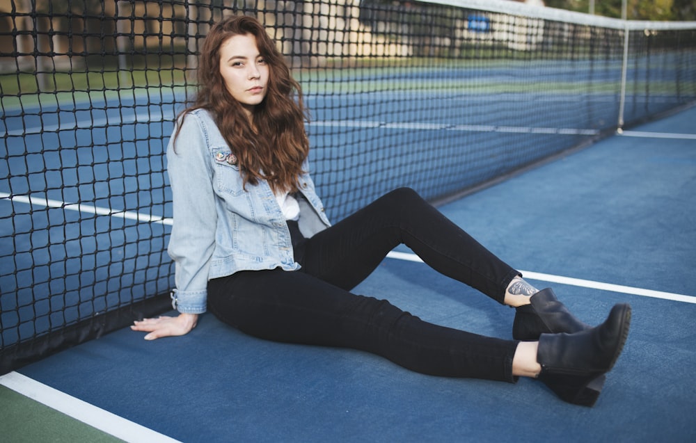 woman sitting on ground beside black net