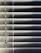 Horizontal blinds partially closed with minimal light seeping through, creating a pattern of alternating light and shadow. A pull cord hangs on the left side of the blinds.