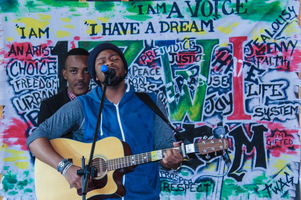 man playing acoustic guitar while singing