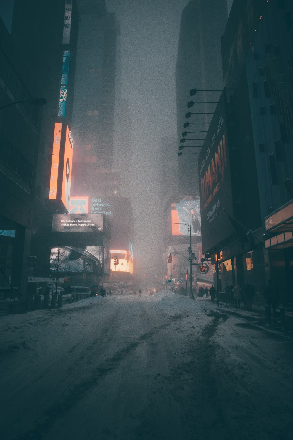 pessoas andando na rua cercada por edifícios da cidade durante a noite