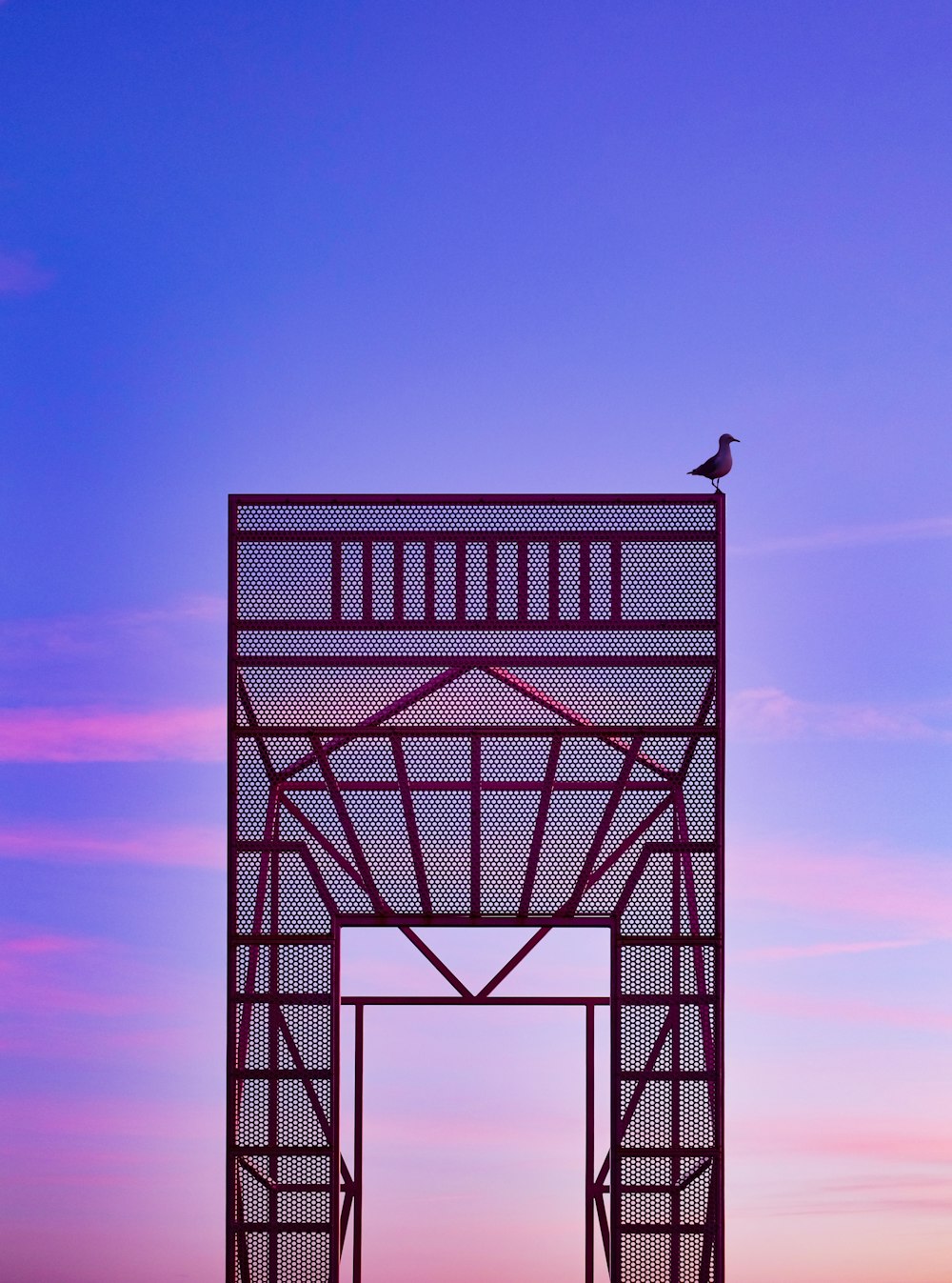 black bird on top of red steel structure