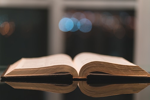 brown opened book on black surface