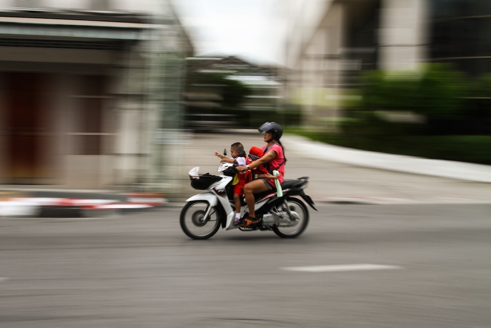 Photographie de bronzage de femme et fille conduisant une moto